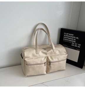 Close-up of cream white PU leather tote bag with functional zippers and pockets