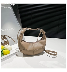 Detail shot of khaki half-moon bag featuring lychee grain texture and fine stitching