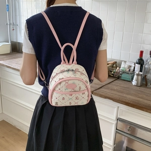 Detail of mini cream backpack with pink trim featuring cartoon bear patterns on jacquard fabric