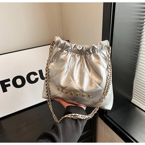 Detail of silver chain bucket bag with quilted patterns and heart logo branding
