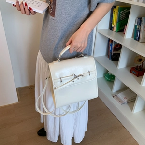 Elegant white leather backpack featuring a top handle and metallic buckle detail