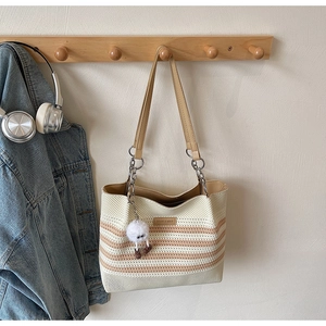 Détail du sac de plage en tricot beige à rayures brunes et charm en peluche