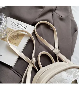 Détail du mini sac à dos en cuir PU crème avec broderie et bandoulière réglable