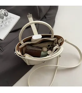 Interior view of off-white lychee leather bucket bag showing capacity for cosmetics