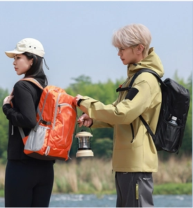 Outdoor hikers wearing orange and black waterproof backpacks walking through a forest