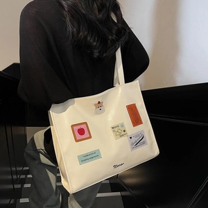 White large-capacity tote bag with artistic patches for women's stylish commuting