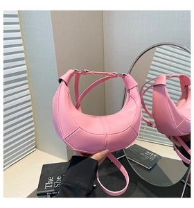 Detail of pink crescent bag showing lychee pattern leather and silver metal buckles