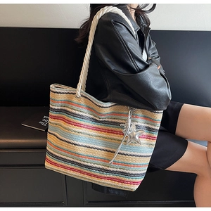 Detail of colorful woven tote bag featuring soft rope handles and star pendant