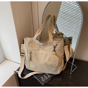 Detailed view of beige nylon tote bag with matching round coin purse and adjustable strap