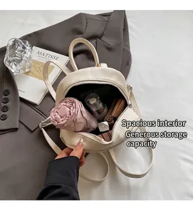 Vue intérieure du mini sac à dos crème montrant l'espace pour parapluie et maquillage