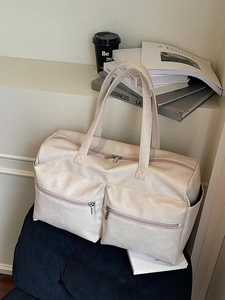 Off-white large capacity PU leather travel tote bag with multi-pocket design on dark surface