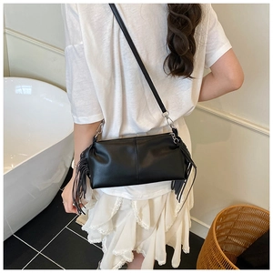 Detailed back view of a black leather handbag with side fringe and silver metal buckles