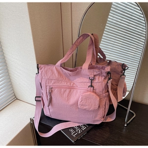 Detail view of pink canvas tote bag with mini coin purse and adjustable strap