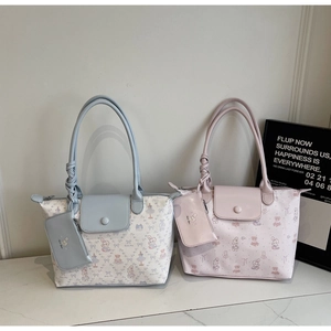 Detail view of cartoon print tote bag with rope handles and matching mini pouch accessory