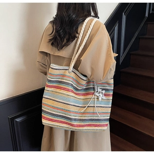 Detail of colorful striped woven tote with cotton rope handles and a star charm