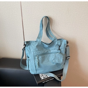 Vue détaillée du sac fourre-tout en nylon bleu clair avec textures et mini porte-monnaie