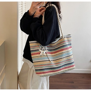 Rainbow striped woven tote bag with white rope handles and silver star charm detail