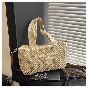 Detailed view of beige woven tote bag with triangle texture and brown leather strap