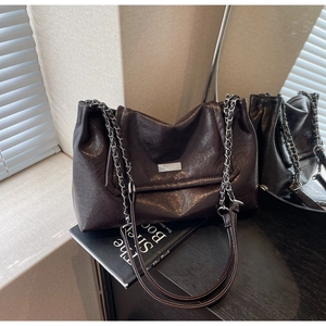 Detail of vintage oil leather shoulder bag with metallic plaque and light shadow effect