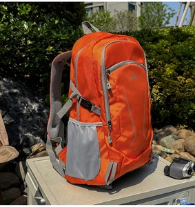 Close-up of orange waterproof outdoor backpack with grid texture and mountain logo detail