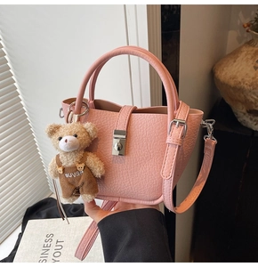 Pink lychee leather bucket bag with adjustable strap and cute teddy bear charm detail