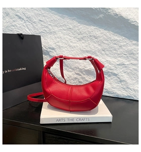 Close-up of red pebbled leather hobo bag with geometric stitching and silver metal rings