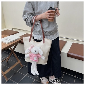 Dettaglio della borsa tote in tela con un simpatico coniglio di peluche 3D e tracolla in pelle