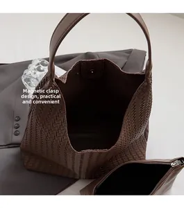 Close-up of brown woven tote bag interior with magnetic closure and leather zip pocket