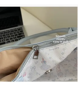 Detail of smooth metal zipper and floral rabbit print on stylish light blue tote bag