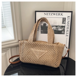 Close-up of large woven knit beach bag with leather strap and inverted triangle texture