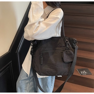 Detail of black large capacity nylon tote bag with pleated texture and mini coin purse