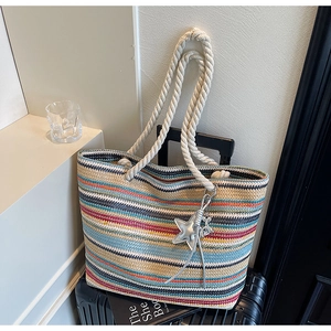 Detail of colorful striped woven tote bag with white rope handles and star pendant charm
