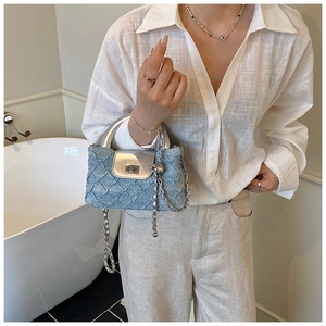 Detail der hellblauen Denim-Minitasche mit silbernem Metallgriff und Kettenriemen