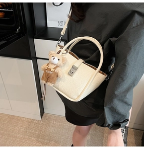 Creamy white lychee leather bucket bag with silver lock and cute plush bear accessory