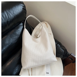 Macro shot of white woven leather texture on a stylish retro tote bag with hobo strap