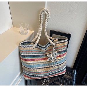 Detail of colorful striped woven tote bag with cotton rope handles and star charm accessory