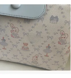 Detail of soft leather tote bag featuring cute bunny and bear pattern illustration