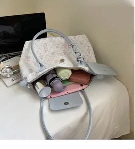 Large capacity light blue tote bag showing interior storage for umbrella and tablet