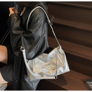 Detail of silver metallic shoulder bag with crinkled texture and sleek chain strap