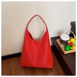 Detailed close-up showing the intricate woven leather texture of a red large tote bag