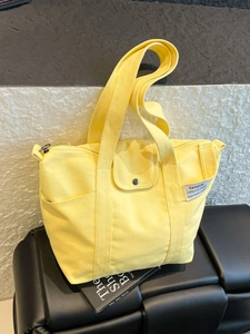 Bright yellow canvas tote bag with wide handles and side pocket for office and college
