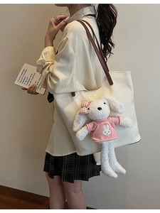 Borsa tote in tessuto bianco sporco con manici in pelle marrone e ciondolo a forma di coniglio