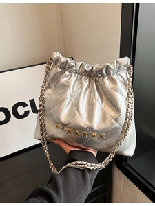Quilted silver chain bag with heart detail and gold letters shown from a front angle
