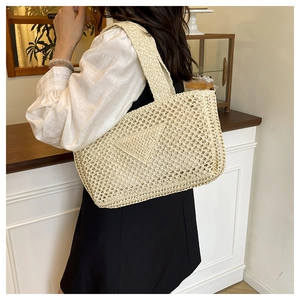 Detail of beige crochet tote bag showing triangle knit pattern and wide shoulder strap