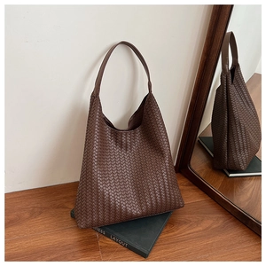 Close-up of luxury dark brown woven leather tote bag with premium cross-weave texture