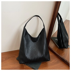 Detail of black hand-woven hobo tote bag texture with large capacity shoulder strap