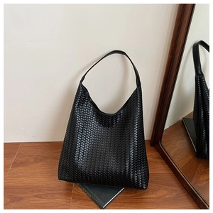 Close-up of black woven hobo bag showing detailed texture and integrated shoulder strap