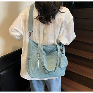Détail du sac fourre-tout bleu clair avec poches multiples et petit porte-monnaie rond