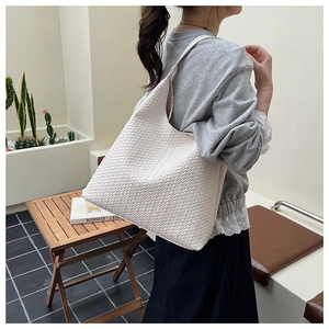Close-up of white woven leather hobo shoulder bag with large capacity texture detail