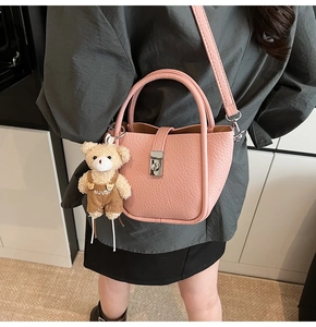Pink lychee grain leather bucket bag with silver clasp and cute bear charm detail